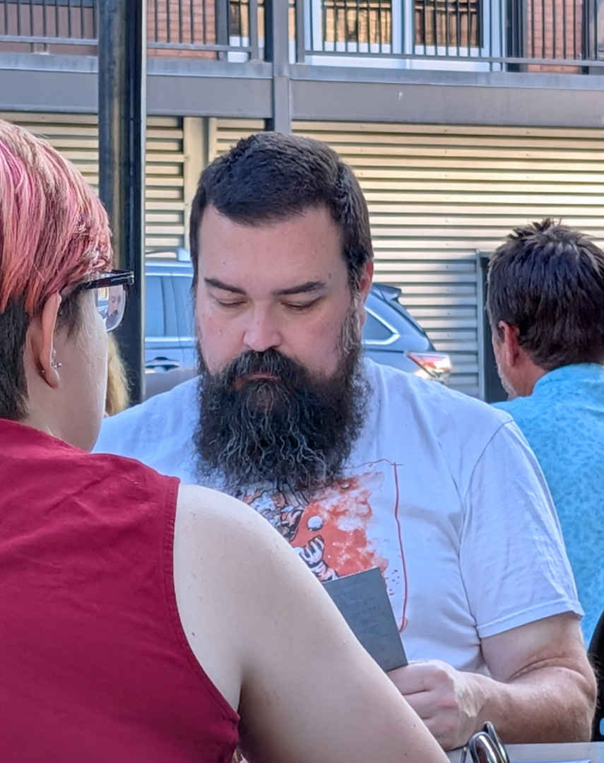 Handsome man with a glorious beard looking at a menu.