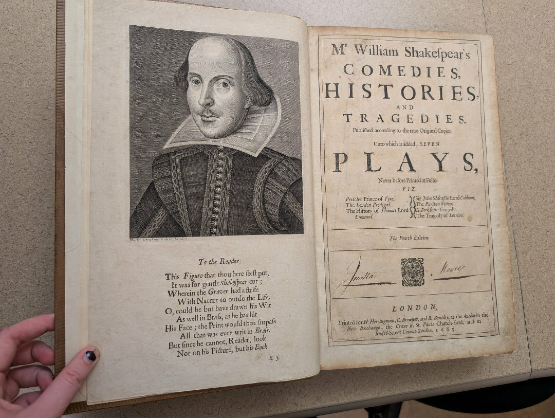 Auto-generated description: A person is holding open a book featuring an engraving of William Shakespeare and the title page of Mr. William Shakespear's Comedies, Histories, and Tragedies.